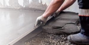 a construction worker is making the floor with concrete products